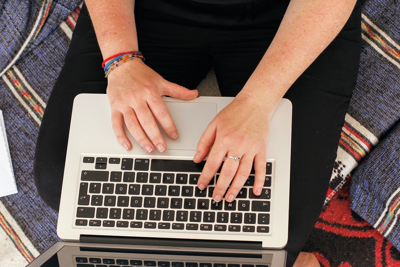 Sofa-bound typing hands on a laptop